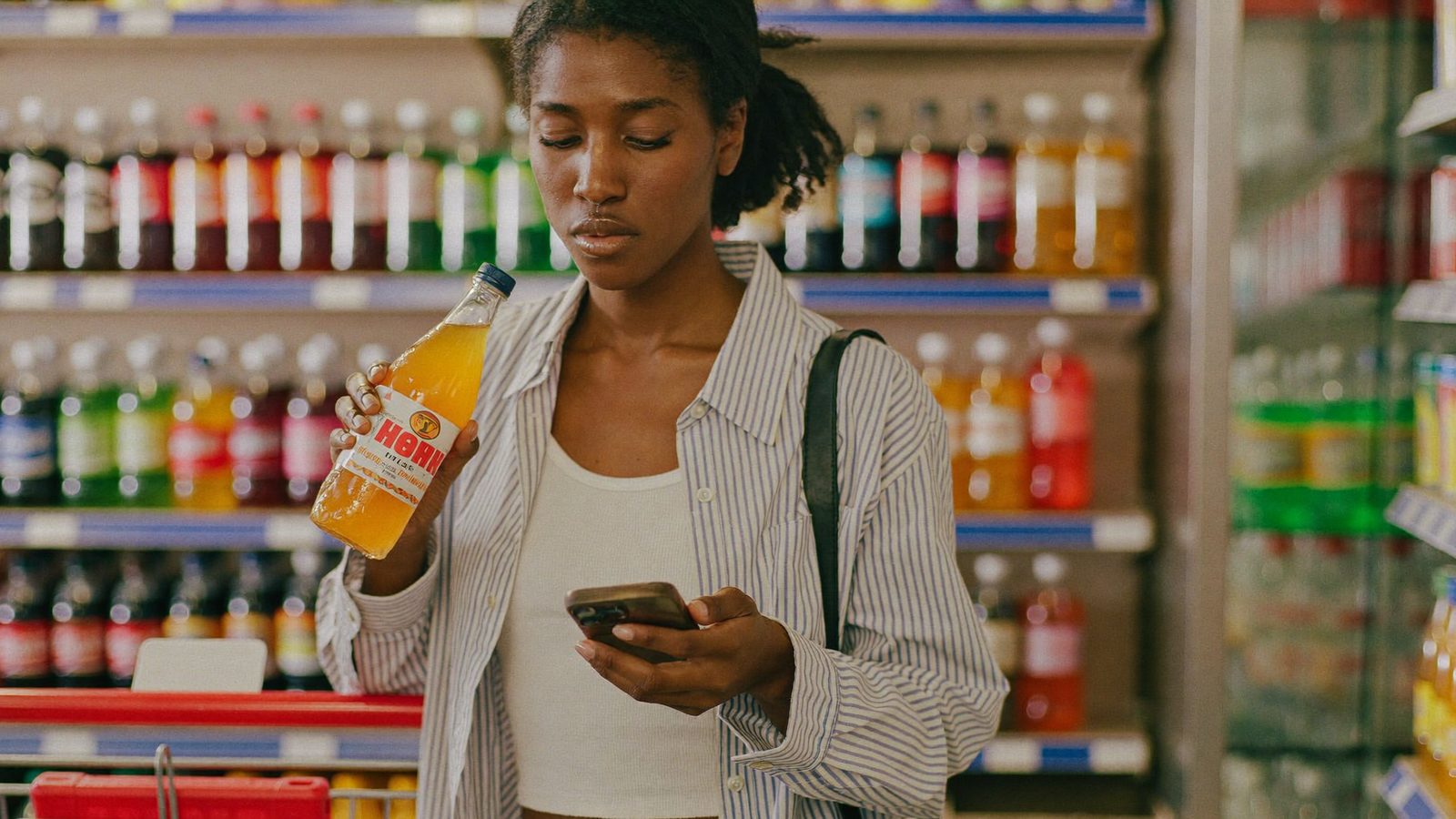 Shopper checking soda label for banned food ingredients with phone scanner app