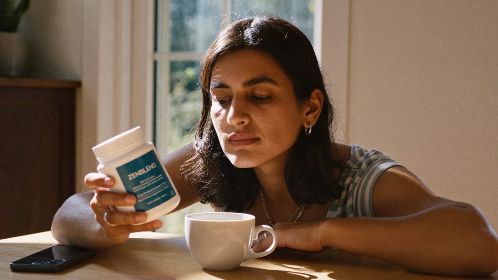 Woman reading a supplement label for banned ingredients at her kitchen table